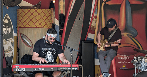 picture of man playing keyboard and a man playing guitar